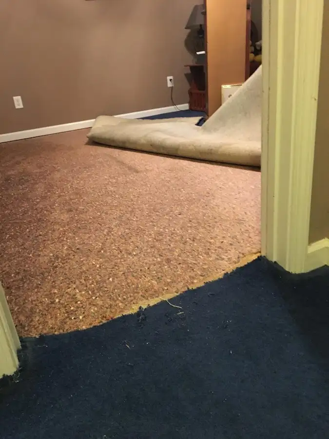 Carpet pad removal revealing water damage during Water Mitigation Services in Coolidge